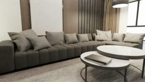 Cozy living room with a large gray sofa and stylish round tables in Scandinavian design.